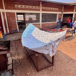 V2SDF training progresses as educators secure the mirror-support panels to the parabolic frame of the SK-23 solar cooker.