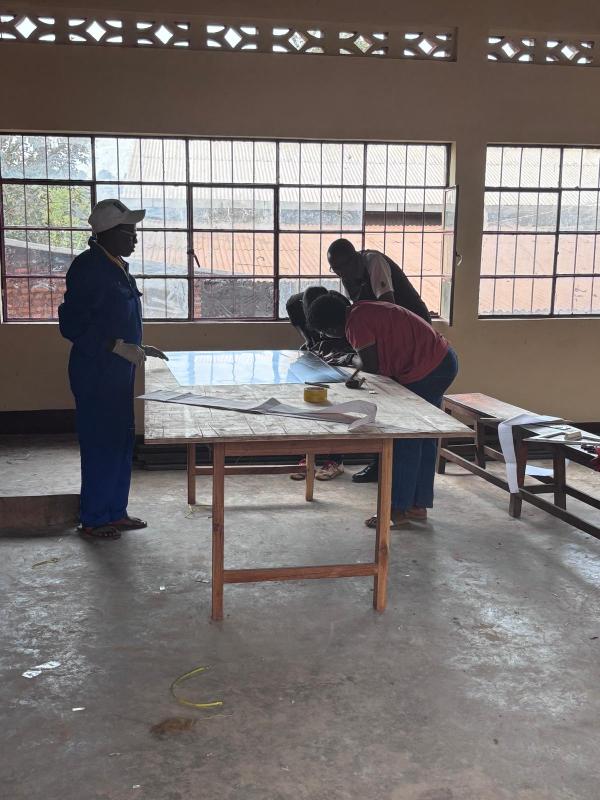 V2SDF training advances to the meticulous process of preparing the mirror substrate for the SK-23 parabolic cooker.