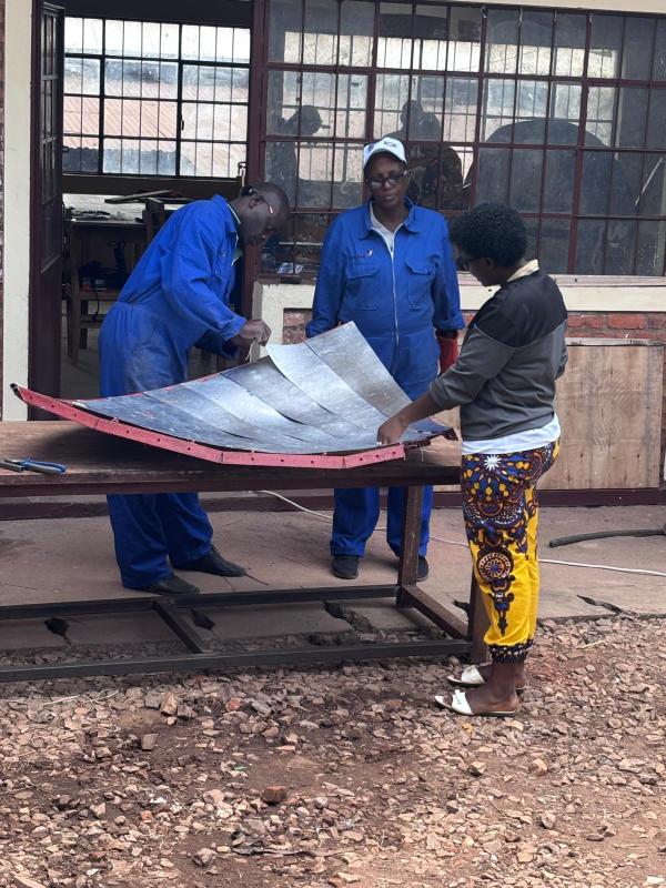 V2SDF training progresses as educators secure the mirror-support panels to the parabolic frame of the SK-23 solar cooker.
